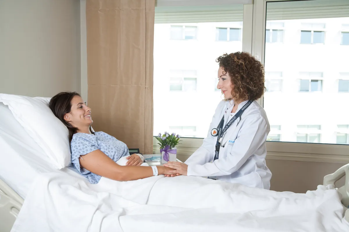 A nurse supporting an international patient at the bedside in a modern room at Anadolu Medical Center